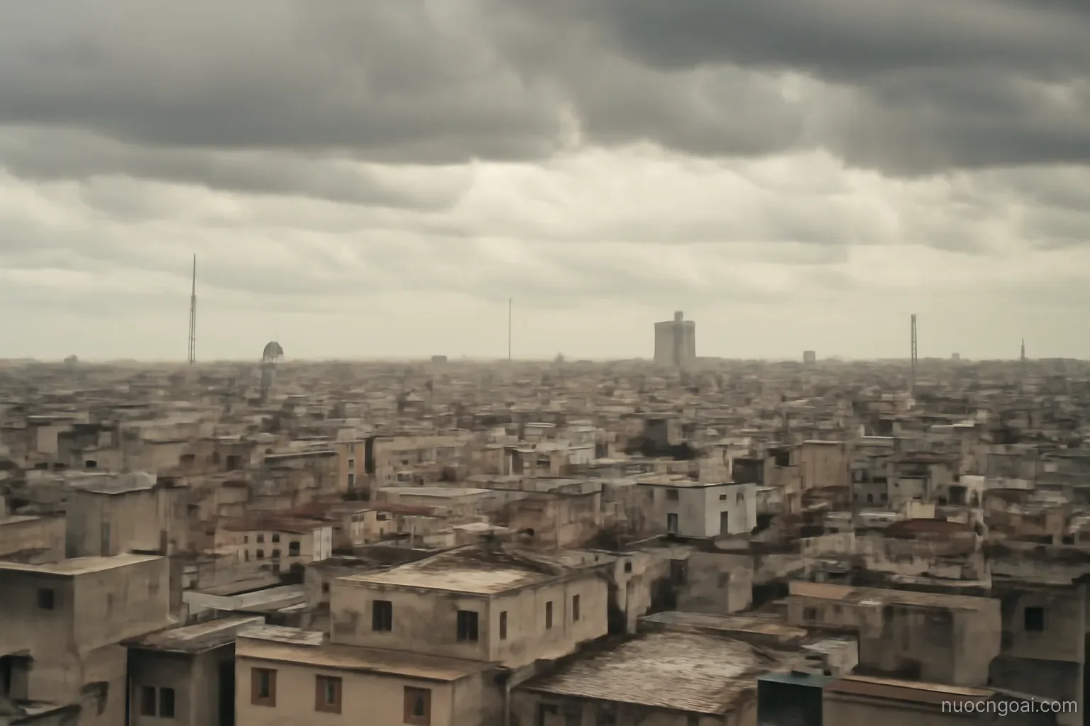 A vast grid of low rooftops and scattered towers stretching past the horizon under heavy tropical cloud