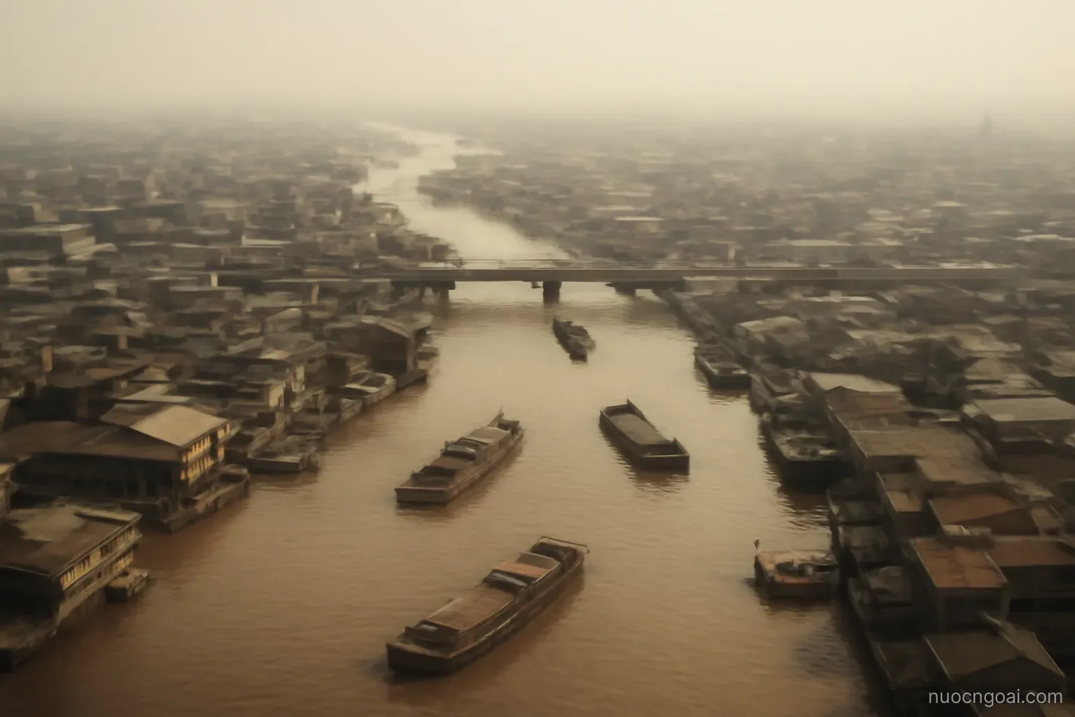 A sprawling delta city of low buildings and bridges over brown creeks, cargo barges under humid haze